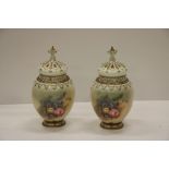 A very good pair of attractive bulbous shaped gilt highlighted and floral decorated Worcester Urns