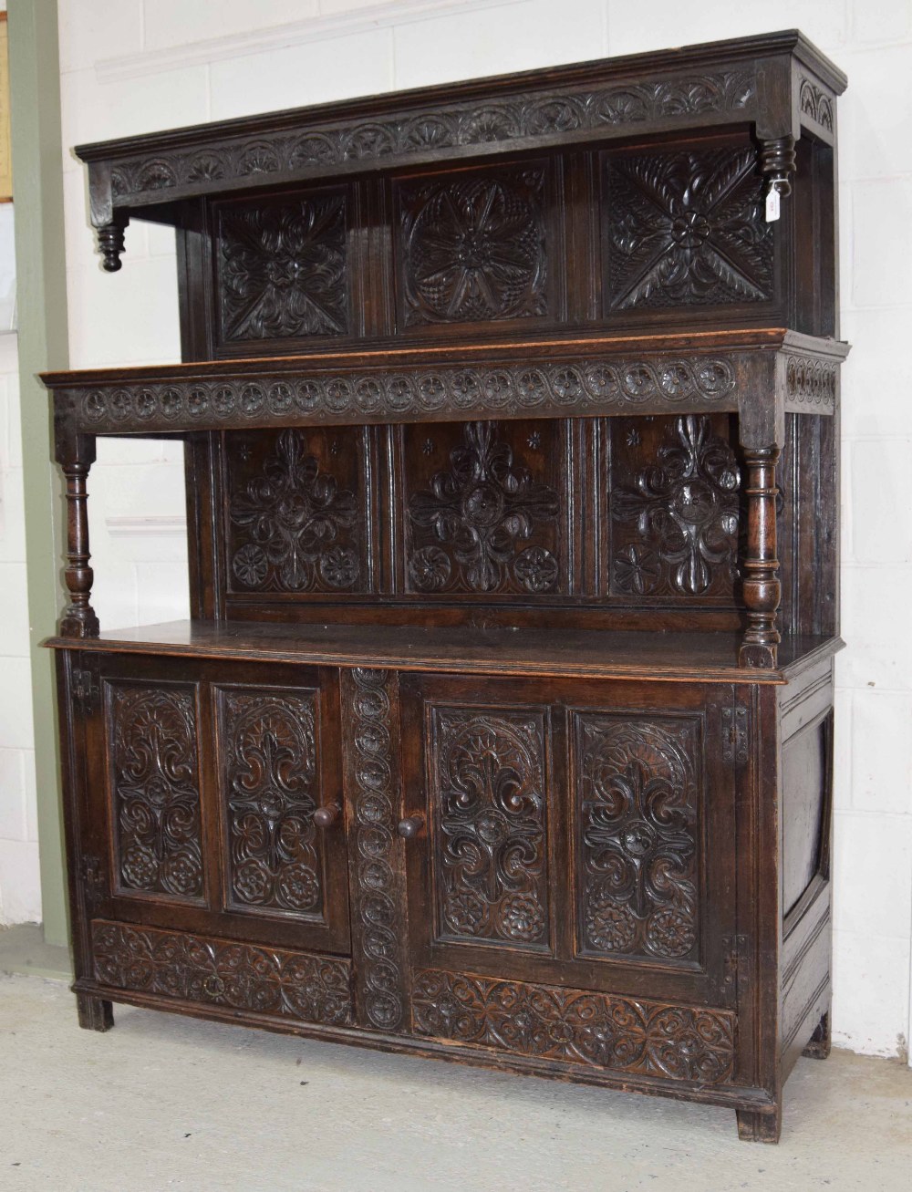 Antique oak tridarn, with a carved open frieze panel over two cupboard doors and two lower