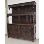 Antique oak tridarn, with a carved open frieze panel over two cupboard doors and two lower