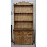 Antique pine dresser with raised shelved back over base of two short drawers over two cupboard