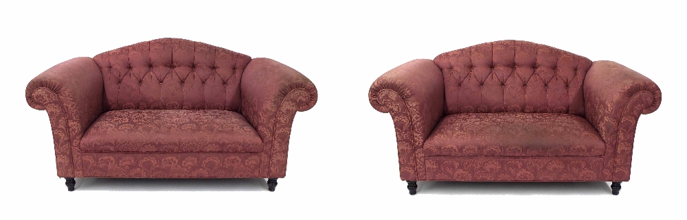 Pair of purple upholstered two-seater Chesterfield settees, with button backs upon short ebonised