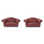 Pair of purple upholstered two-seater Chesterfield settees, with button backs upon short ebonised