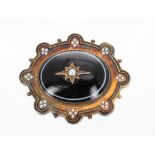 Victorian onyx enamel and yellow metal mourning oval brooch, the centre with a seed pearl and star
