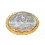 19th century oval ivory brooch in an engraved yellow metal mount, painted with a scene depicting