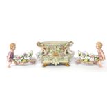 German style porcelain cherub centrepiece, raised on four feet, 7.5" high, 12" wide; together with a