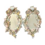 Pair of Meissen style porcelain wall mirrors, with encrusted floral frames each featuring a