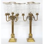 Tall pair of Corinthian style brass five branch candelabra, each with glass storm shades, 31"
