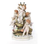 Dresden style porcelain cherub group, modelled with four cherubs upon a naturalistic rocky base,