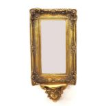 Antique style decorative gilt framed wall mirror, the bevelled rectangular glass within a foliate