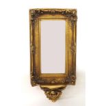 Decorative gilt framed wall mirror, the bevelled rectangular glass within a foliate scrolling carved