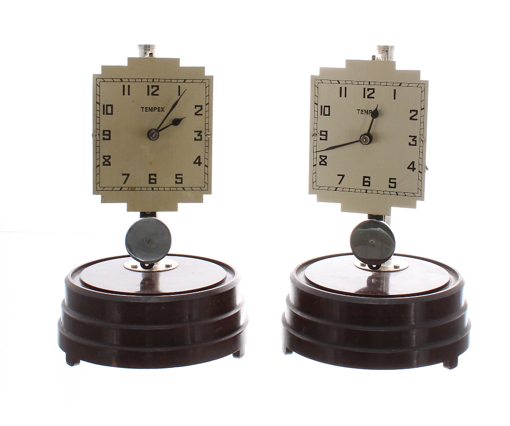 Two Tempex Art Deco electric clocks on Bakelite bases, under domes, with chrome posts and pendulums,