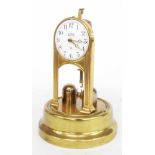 Tiffany Never Wind electric torsion clock, under a glass dome and upon a spun brass base, 10" high