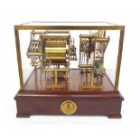 Brass slave exhibition strike/chime movement, within a brass bound case and upon a mahogany base