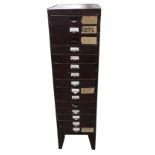 Clockmaker's metal upright chest of fifteen short drawers with contents including: clock parts,