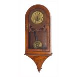 Figured walnut two train wall clock striking on a gong, the 6" brass dial within a rounded arched