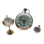 Large reproduction brass bound ball clock of erotic interest, surmounted by a ring handle, 8" high