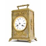 Brass two train mantel clock striking on a bell, the 3.5" white dial within an ornate gilt metal