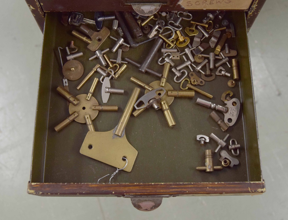 Clockmaker's metal upright chest of fifteen short drawers with contents including: clock parts, - Image 2 of 7