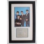 The Beatles - autographed page mounted within a framed display below a picture of the Fab Four *