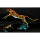 A Large Coldpainted Bronze In The form Of A Leaping Cheetah Raised on organic form black marble