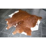 Large Cowhide Rug Of traditional form in chestnut and white hair, 6ft square,