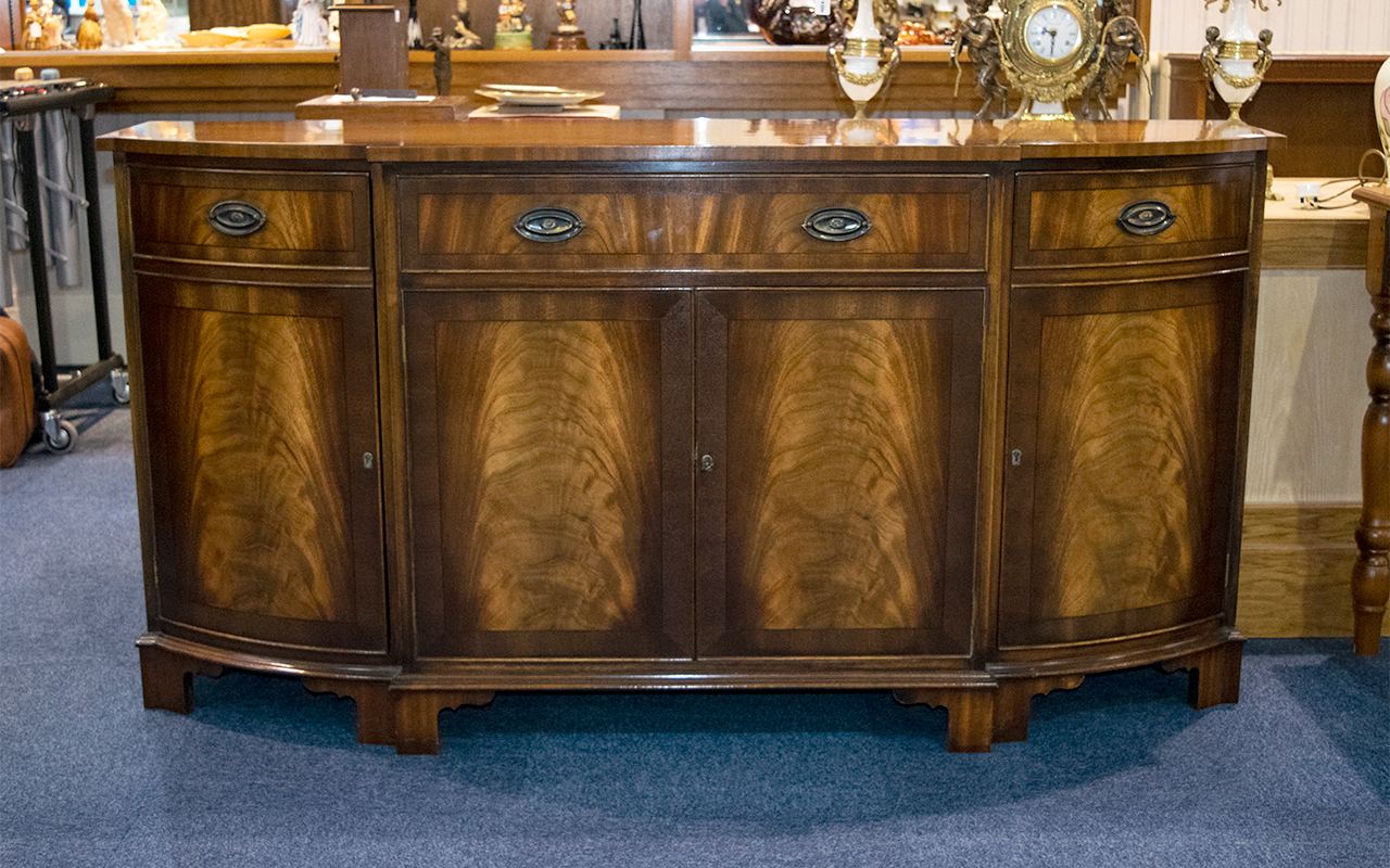 A 1980's Brake Front Mahogany Sideboard Comprising central drawer above and between storage