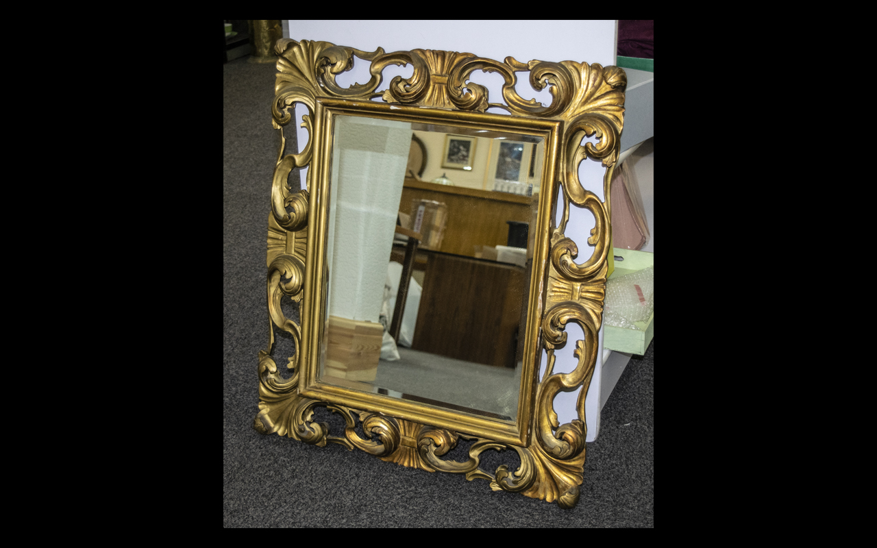 Bevelled Glass Mirror Large decorative mirror in ornate gilt swept reproduction rococo frame.