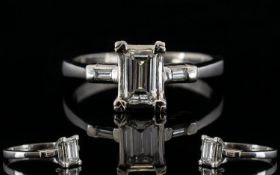 Platinum Emerald Cut Diamond Ring The central stone, set between two emerald cut diamond shoulders,