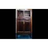 A Mid-Late 20th Century Oriental Style Cabinet Openwork lattice doors above panel doors with carved