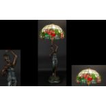 A Reproduction Tiffany Style Lamp Bronzed resin figural lamp with canopy shade in leaded opaque