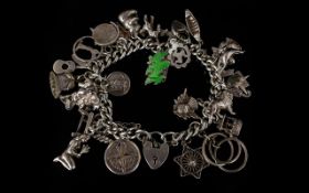A Silver Charm Bracelet Loaded With Charms Approx 20 charms to include seahorse, guitar,