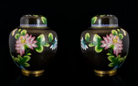A Pair Of Oriental Cloisonne Lidded Jars Ovoid form squat ginger jars, black ground profusely