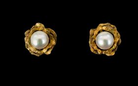 A Pair Of 9ct Gold And Faux Pearl Set Earrings Stud earrings in the form of stylised flowers,