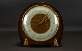 A Mid 20th Century Mantel Clock Of typical form in curved wood case with gold tone filigree