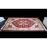 A Large Woven Silk Carpet Ornately patterned Heriz rug with iron red ground and traditional Middle