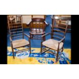 A Pair Of Lancashire Ladder back Chairs comprising armchair and rocker with traditional rush seats.