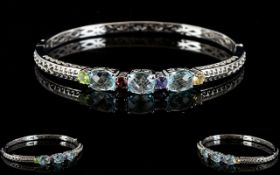 Sky Blue Topaz and Multi Gem Bangle, three oval cut sky blue topaz with chequerboard faceting to the