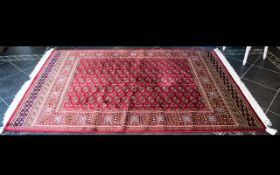 A Large Woven Silk Bokhara Carpet Ornate silk carpet with traditional lozenge and geometric repeat