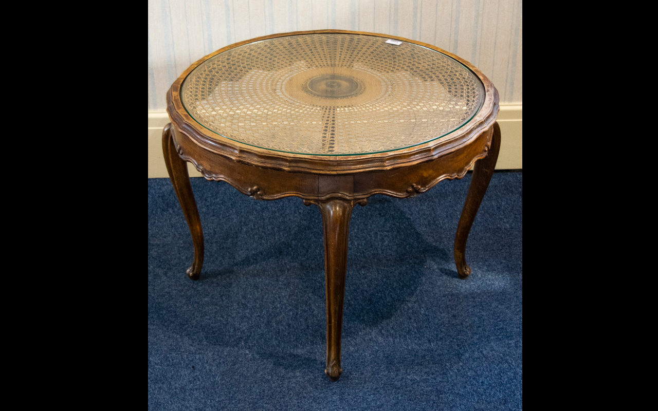 A Circular Occasional Table raised on scroll feet with fluted edge and glass inlay top with woven