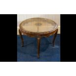 A Circular Occasional Table raised on scroll feet with fluted edge and glass inlay top with woven