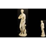 A Floor Standing Resin Figure In The Form Of Diana At Her Bath Female Nude, Resting Against Plinth.