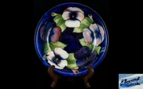 William Moorcroft Footed Bowl with Pansy Pattern on Blue Ground. Impressed Moorcroft Marks to