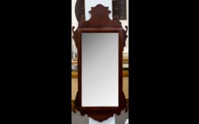 A Reproduction Georgian Style Bevelled Glass Mirror In shaped Mahogany finish frame. 20 x 43. Good