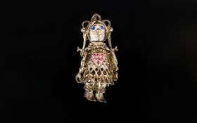 A White Metal Articulated Pendant The whole in the form of a rag doll with crystal set eyes and