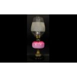 An Early 20th Century Oil Lamp Of Typical form with pink ombre glass reservoir,