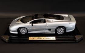 A Maisto 1:12th Scale Diecast Model Jaguar Model: XJ220 (1992) Displayed On Plastic Plinth.