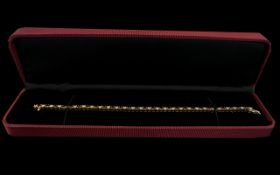 A 14 ct Diamond Tennis Bracelet Set with alternating rubies and brilliant cut diamonds, length 7 1/4