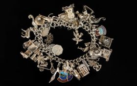 A Silver Charm Bracelet Loaded With Over Thirty Charms To include Taj Mahal, church, anchor, clock,