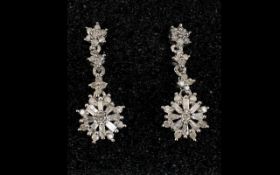 Diamond Pair of Drop Earrings, a starburst shape drop comprising baguette and round cut diamonds,