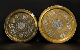 Two Antique Islamic Brass Chargers Each with inlaid silver script, diameters 18 and 16 inches.